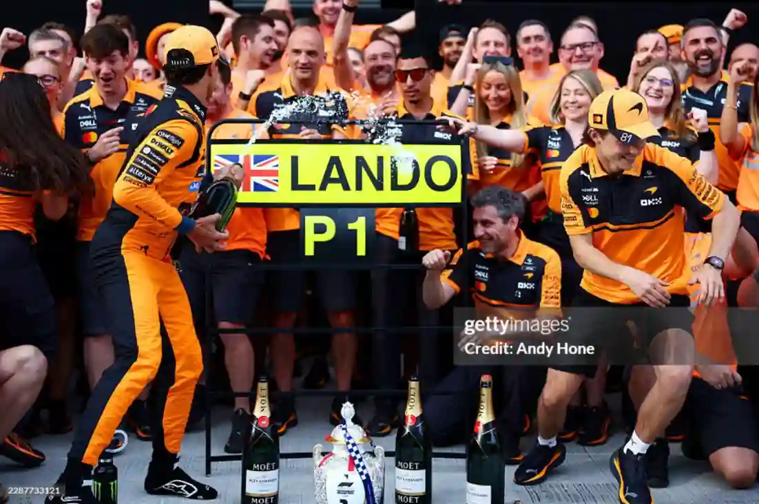 Lando Norris celebrating with the McLaren F1 Team in front of his P1 pit board at the Hungarian Grand Prix